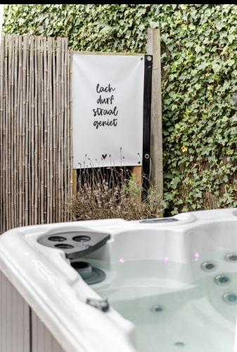 a bath tub with a sign that says lack cant shoot yourself at Slapen bij van O 1 in Yerseke