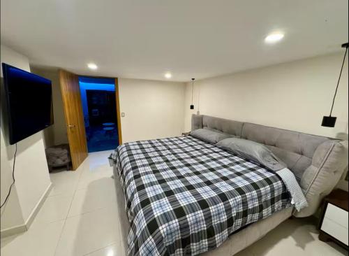 a bed in a room with a couch and a tv at Zona Rosa Amberes 33 a 2 cuadras del CAS y del Ángel in Mexico City