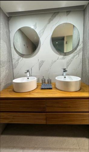 a bathroom with two sinks and two mirrors on a counter at Zona Rosa Amberes 33 a 2 cuadras del CAS y del Ángel in Mexico City
