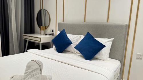 a bedroom with a bed with blue pillows and a mirror at Axon Residence Near Fehrenheit Bukit Bintang in Kuala Lumpur
