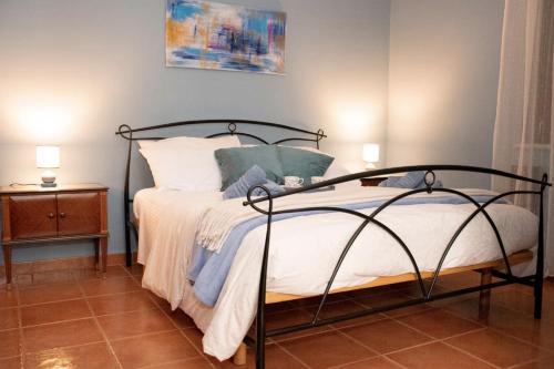 a bedroom with a bed with a black frame and white sheets at The Oaks in Spigno Saturnia