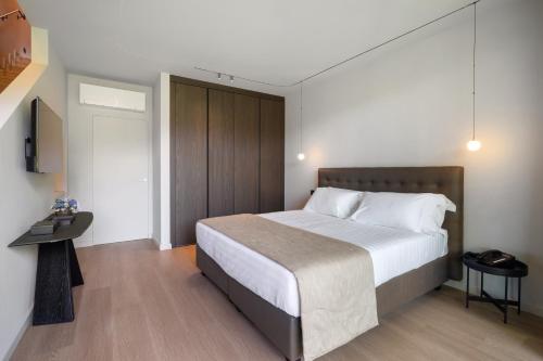 a bedroom with a large bed and a television at Park Hotel Villa Belvedere in Cannobio