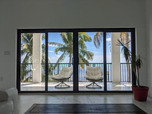 a living room with a view of the ocean and palm trees at Horizon in Marathon