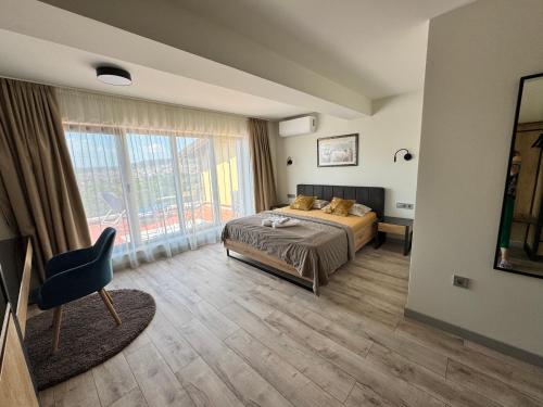 a bedroom with a bed and a large window at Province Stone House Varna in Varna City