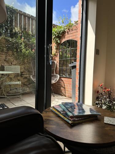 ein Tisch mit Büchern darauf neben einem Fenster in der Unterkunft Trevor Street in Holywood