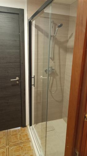 a shower with a glass door in a bathroom at Hostel Elios in Lorca