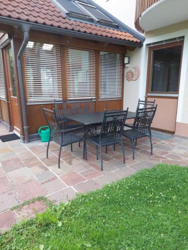 a patio with four black chairs and a table at Appartement Wintergarten in Seenähe 
