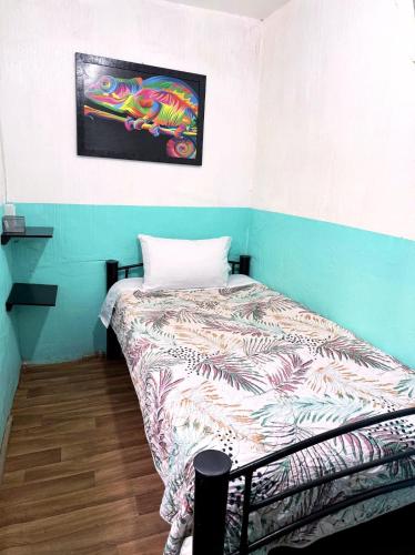 a bedroom with a bed with a painting on the wall at Alo México in Mexico City