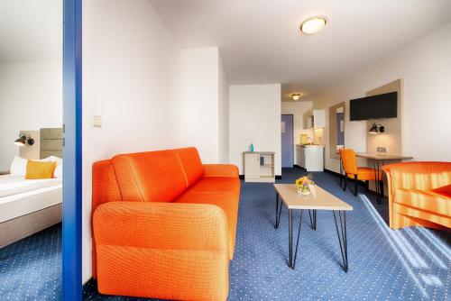 a living room with a couch and a table at ACHAT Hotel Zwickau in Zwickau