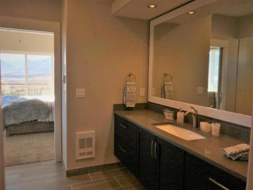 a bathroom with a sink and a large mirror at Barnwood Chateau With 2 Master Suites Hot Tub in Salida