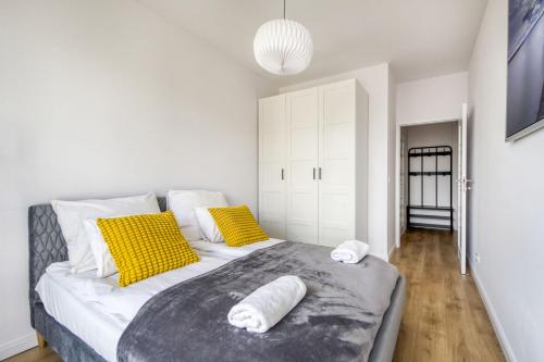 a bedroom with a large bed with yellow and white pillows at Warsaw Night Apartments Zloty Potok Lotnisko Chopina in Warsaw