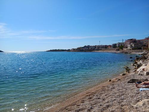 a person laying on a beach near the water at Appartamento I TRE SANTI in Bisceglie