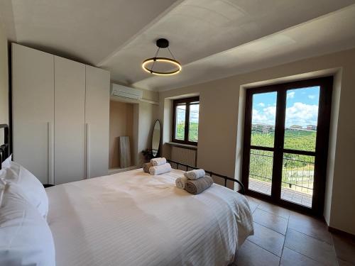 a bedroom with a white bed with two towels on it at Relais Portaluna delle Langhe in Mango