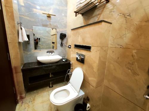 a bathroom with a white toilet and a sink at Shri Shyam Luxury Hotel in Har Ki Paudi in Haridwār