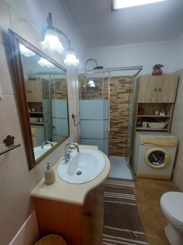a bathroom with a sink and a toilet and a mirror at Casa Maria T1 in Armação de Pêra