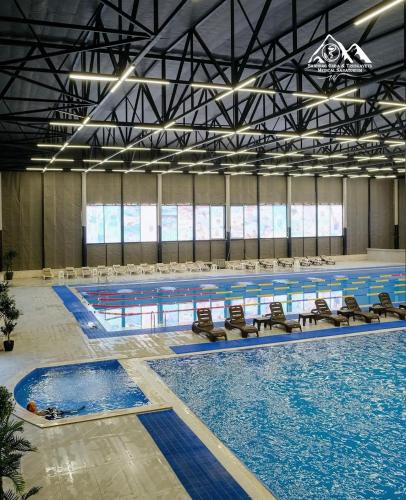 a large indoor swimming pool with chairs and water at The River View Villa الحلال Halal Concept in Quba