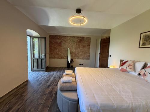 a bedroom with a large bed and a couch at Relais Portaluna delle Langhe in Mango