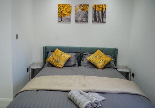 1 dormitorio con 1 cama con 2 cuadros en la pared en Delightful 1-Bedroom Apartment with Garden, en South Norwood