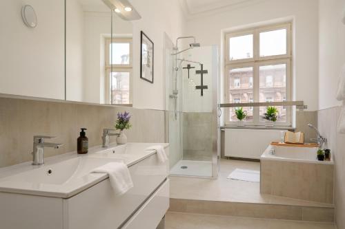 a white bathroom with two sinks and a shower at Wohnkultur - Altbau Charme für 8 Personen in Mannheim