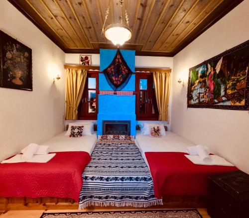 two beds in a room with a fireplace at Meliteion Traditional Hotel in Asprangeloi