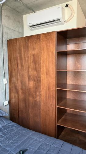 a bedroom with a bed and a wooden closet at Céntrico departamento con vista espectacular in Monterrey