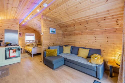a living room with a blue couch in a cabin at Hugo in East Cowton