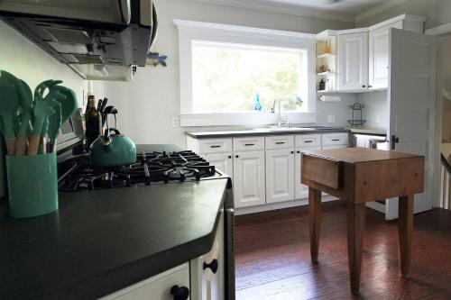 a kitchen with white cabinets and a stove top oven at Charming Home On The Point in Newport