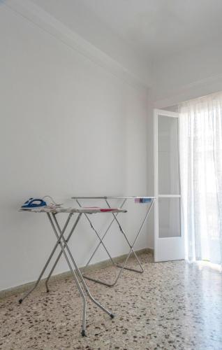 a glass table in a room with a white wall at 5 steps from the sea in Kalamata