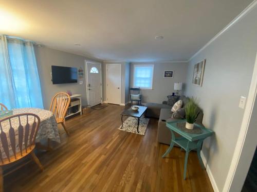 ein Wohnzimmer mit Sofa und Tisch in der Unterkunft Willows Cottage West in Dennis Port