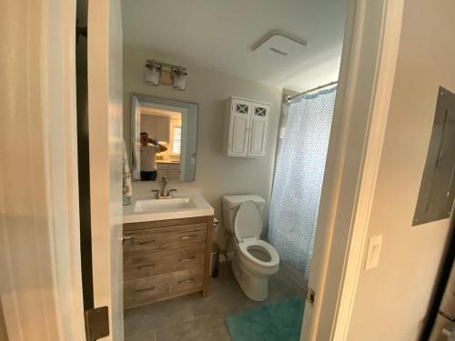 ein Badezimmer mit Toilette, Waschbecken und Spiegel in der Unterkunft Willows Cottage West in Dennis Port