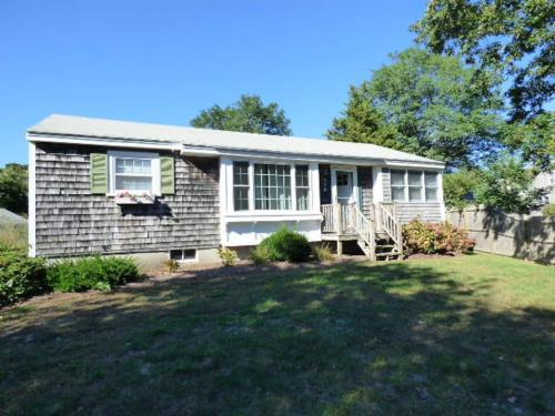 a small house with a lawn in front of it at Willows Main House in Dennis Port