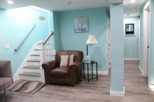 a living room with blue walls and a chair and stairs at Willows Main House in Dennis Port