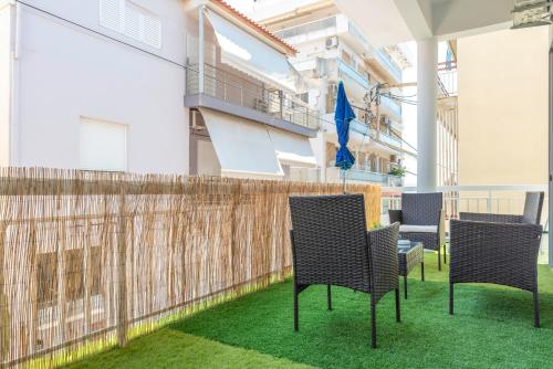 a balcony with chairs and a fence at 5 steps from the sea in Kalamata