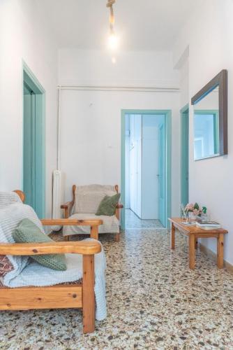 a living room with two benches and a table at 5 steps from the sea in Kalamata