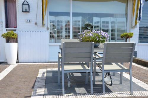 twee stoelen en een tafel op een patio bij Pension 't hofje 350 meter van het strand in Noordwijk aan Zee
