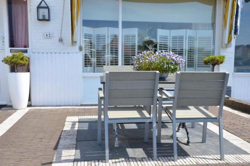 Dos sillas y una mesa en un patio. en Pension 't hofje 350 meter van het strand, en Noordwijk aan Zee