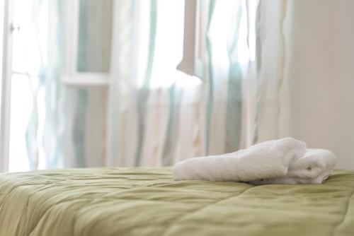 a white towel sitting on top of a bed at 5 steps from the sea in Kalamata