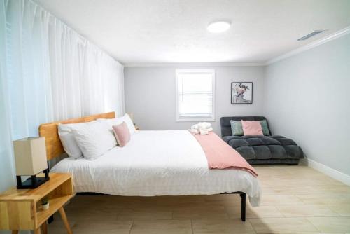 a bedroom with a bed and a couch at Tranquil & Fully Renoveted Home Near Busch Gardens in Tampa