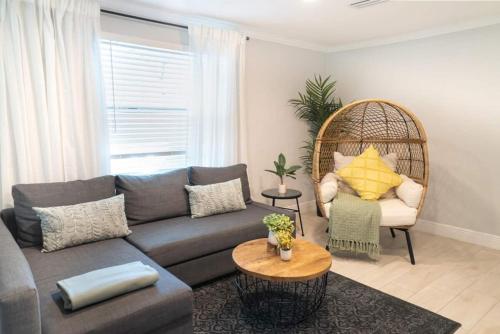 a living room with a couch and a chair at Tranquil & Fully Renoveted Home Near Busch Gardens in Tampa