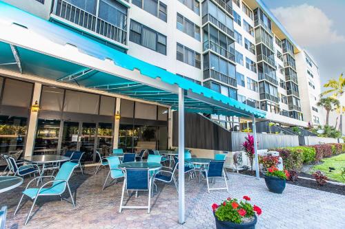 a patio with tables and chairs in front of a building at Upgraded and Spacious Harbor Towers Condo! Siesta Key Vacation! in Siesta Key