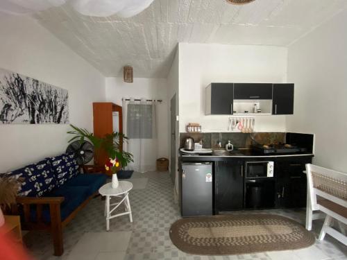 a living room with a blue couch and a kitchen at Elala Studio Homes in Diani Beach