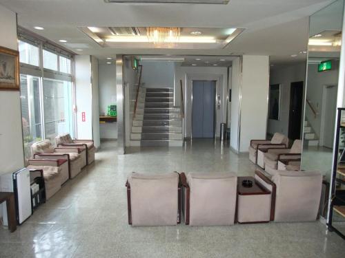 a lobby with chairs and stairs in a building at Hotel New Takahashi Kouyadai in Tsukuba