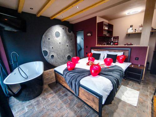 una camera da letto con un grande letto con palloncini rossi sopra di Wezly Tiny House a Măgura