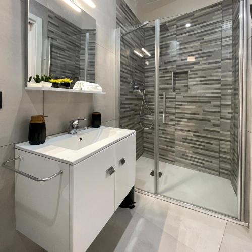 a white bathroom with a shower and a sink at La Viuzza Rooms in Barletta