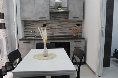a kitchen with a table with a vase on it at La Viuzza Rooms in Barletta