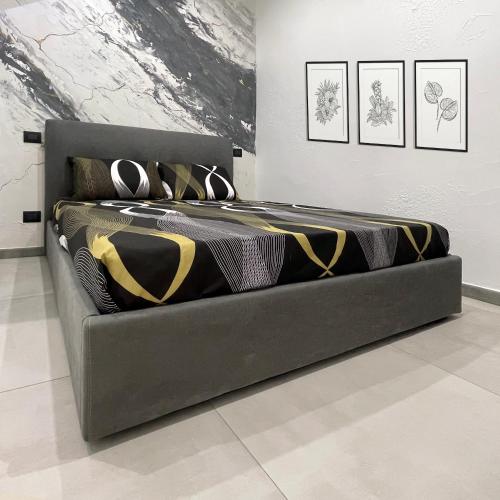 a black bed in a room with paintings on the wall at La Viuzza Rooms in Barletta