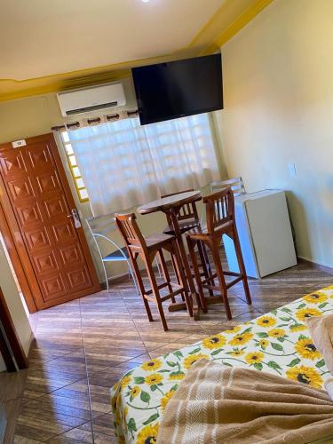 a room with a kitchen with a table and chairs at Hotel Pousada Mozini's in Tupã