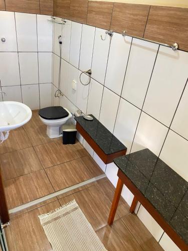 a bathroom with a toilet and a sink at Hotel Pousada Mozini's in Tupã