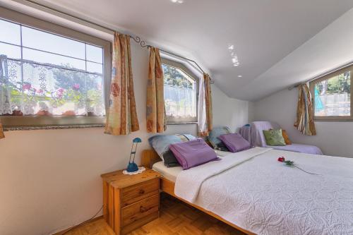 1 dormitorio con 1 cama y 2 ventanas en Apartments Ljiljana, en Pula
