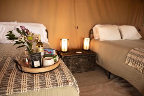 a hotel room with a table with a bottle of wine and flowers at Boutique Vineyard Stay at Painted Prairie in Currie